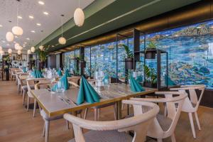 a restaurant with tables and chairs and a large mural at art'otel cologne in Cologne +117 photos