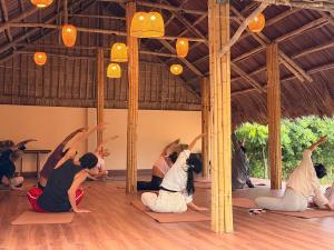 a group of people doing yoga in a room at B'Hoian Retreat in Hoi An