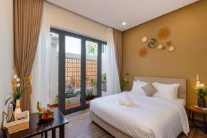 a bedroom with a white bed and a large window at Fusia Hotel & Apartment in Danang +115 photos