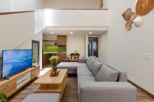 a living room with a couch and a tv at Fusia Hotel & Apartment in Danang