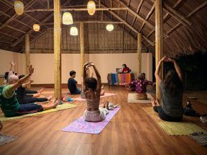 a group of people sitting in a yoga class at B'Hoian Retreat in Hoi An