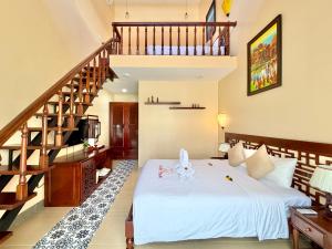 a bedroom with a white bed and a staircase at B'Hoian Retreat in Hoi An +65 photos