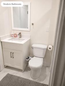 a white bathroom with a toilet and a sink at New 2BR Central AC Laundry Private Entry Parking in Milton +9 photos