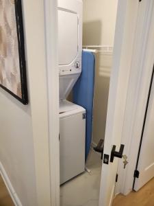 a bathroom with a washer and dryer next to a door at New 2BR Central AC Laundry Private Entry Parking in Milton