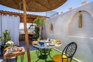 a patio with a table with food on it at Riad Nadalinn in Marrakesh