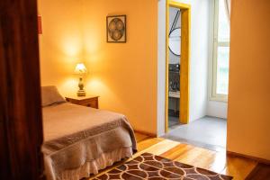 a bedroom with a bed and a door to a window at Sitio da Paz Celestial in Nova Petrópolis