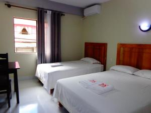 a bedroom with two beds and a window at Pampa & Selva in Rurrenabaque