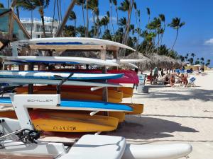 a pile of surfboards sitting on a beach at Coral Beach Hotel Punta Cana in Punta Cana