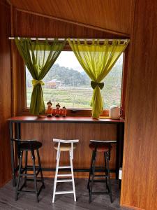 a bar with two stools in front of a window at An's House homestay & Hagiang local tours in Ha Giang