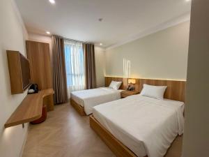 a hotel room with two beds and a television at Sơn Trà 668 in Sa Vi Xom