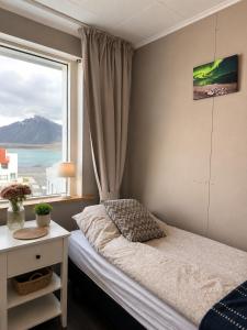 a bedroom with a bed and a large window at Aurora Apartament in Borgarnes