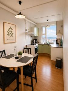 a kitchen and dining room with a table and chairs at Aurora Apartament in Borgarnes