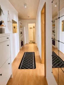 a hallway with a rug on the floor and a mirror at Aurora Apartament in Borgarnes +13 photos
