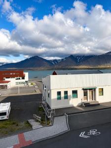a white building with mountains in the background at Aurora Apartament in Borgarnes