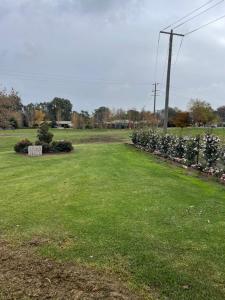a field with a row of flowers in the grass at Guinevere2 in Myrtleford