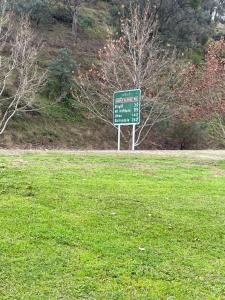 a green sign sitting in the middle of a field at Guinevere2 in Myrtleford