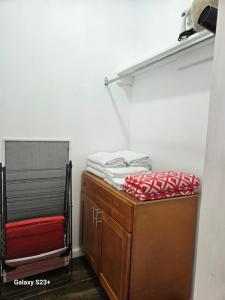 a room with a closet with a shelf and a pile of towels at Tim Pappies Nature Lodge - Kai's Place in Port Antonio