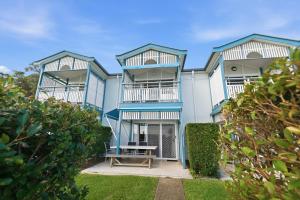 a blue and white building with a bench in front of it at Villa 3 Beach Front Tangalooma in Tangalooma