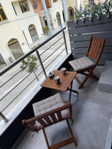 a table and chairs on a balcony with a table and chairs at 11 Diamond Drive, Luxury Bright & Quiet City Center Loft, Easy Access in Kavála
