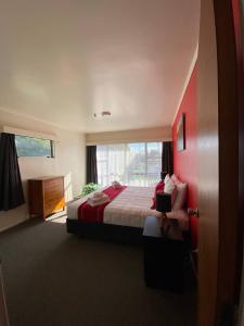a hotel room with a bed and a window at Waitangi Beach House in Paihia