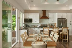 a kitchen with a table and chairs and a kitchen with white cabinets at Lakeside Lodge with Studio Apartment in Monticello
