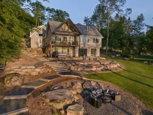 a house with a fire pit in the yard at Lakeside Lodge with Studio Apartment in Monticello