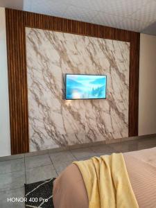 a tv on a marble wall in a bedroom at ZU Apartamentos in Los Algarrobos