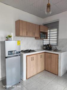a kitchen with a white refrigerator and wooden cabinets at ZU Apartamentos in Los Algarrobos