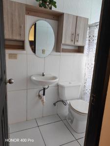 a bathroom with a toilet and a sink and a mirror at ZU Apartamentos in Los Algarrobos +18 photos