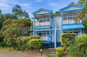 an apartment building with blue balconies and trees at Villa 30 Tangalooma in Tangalooma