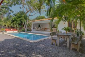 a villa with a swimming pool and a table and chairs at Casa Brasil Careyes in Careyes