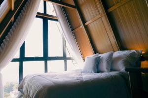 a bed in a room with a large window at Cabanas Monte Cristo in Serafina Corêa