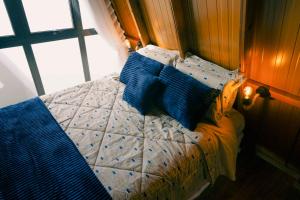 a bed with blue pillows on it in a bedroom at Cabanas Monte Cristo in Serafina Corêa