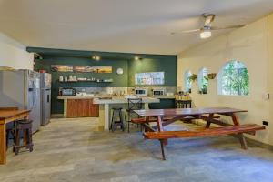 a large kitchen with a wooden table and a dining room at Hostel La Botella de Leche - Tamarindo in Tamarindo