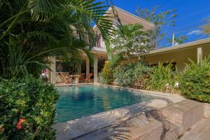 a swimming pool in front of a house at Hostel La Botella de Leche - Tamarindo in Tamarindo