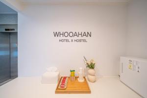 a table in a room with a sign on the wall at Hotel Whooahan Suyu in Seoul +85 photos