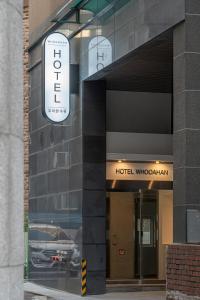 a hotel building with a sign on the side of it at Hotel Whooahan Suyu in Seoul
