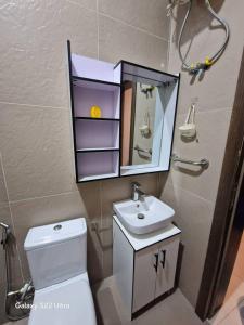 a bathroom with a toilet and a sink and a mirror at Nest Nova in Alagbado