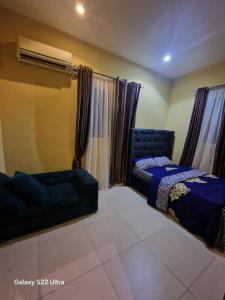 a bedroom with a bed and a couch and curtains at Nest Nova in Alagbado
