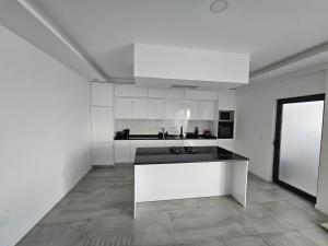 a kitchen with white cabinets and a black counter top at Palmarejo grande in Praia