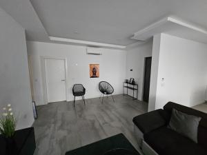a living room with two chairs and a couch at Palmarejo grande in Praia