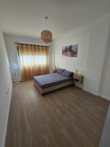a bedroom with a bed and a large window at Palmarejo grande in Praia