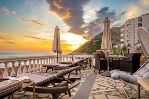 a balcony with chairs and umbrellas on the beach at Vila Dora in Dobra Voda +93 photos