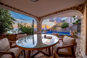 a dining room with a glass table and chairs at Vila Dora in Dobra Voda