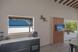 a kitchen with a window with a view of the ocean at La Villa de Solange - Canope in La Trinité +30 photos