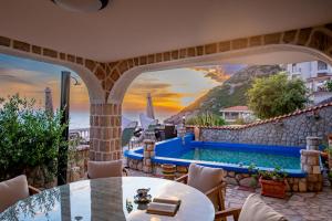 a patio with a pool and a table and chairs at Vila Dora in Dobra Voda