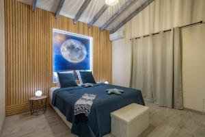 a bedroom with a blue bed and a picture of the moon at La Villa de Solange - Azur in La Trinité