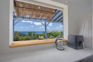 a kitchen window with a view of the ocean at La Villa de Solange - Azur in La Trinité +39 photos