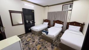a hotel room with two beds and a mirror at صالة المدينة 2 in Medina