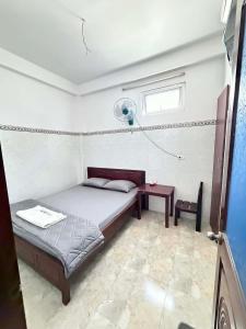 a bedroom with a bed and a table and a window at Nhà Nghỉ Hoa Lan2 in Buon Ma Thuot +4 photos